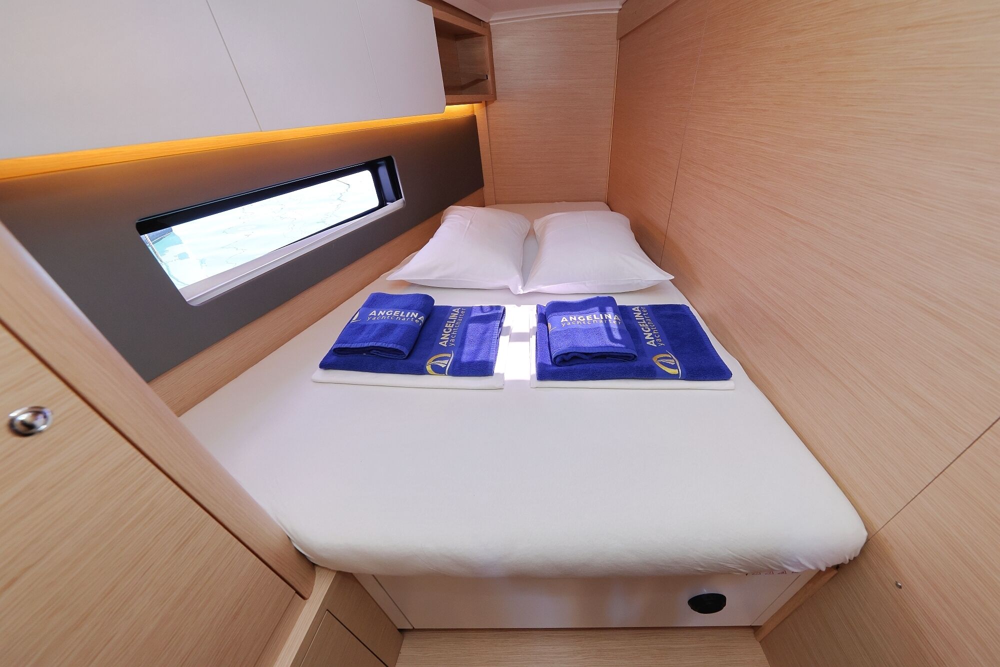 A small cabin with a bed, a window, and a control panel.
