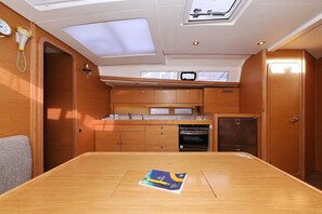 Eine kleine Küchenzeile mit Holztisch, Mikrowelle und kleinem Kühlschrank.