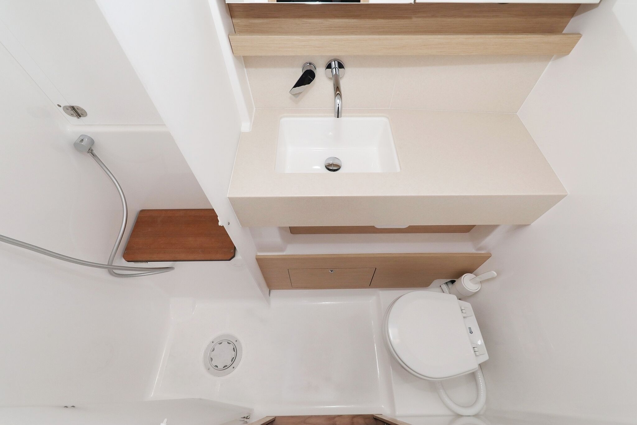 Une salle de bain avec un lavabo blanc, un meuble-lavabo en bois et des toilettes.