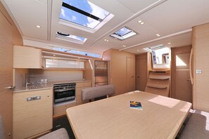 A compact kitchen with a stove, sink, and overhead skylights.