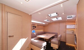 A compact, well-lit interior with a kitchenette, seating area, and a door leading to another room.