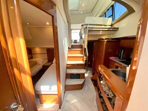 A compact interior with a bed, a small kitchenette, and a window. - Sun-Kissed Sailing Adventure in Sibenik, Croatia (Primošten)