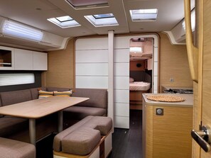Ein kompaktes Wohnmobil-Interieur mit Essbereich, Sitzgelegenheiten und einer kleinen Küche.