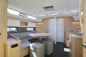 A compact RV interior with a kitchenette, a dining area, and a seating space. - Sibenik Sun and Beach Sailing Extravaganza (Tribunj)