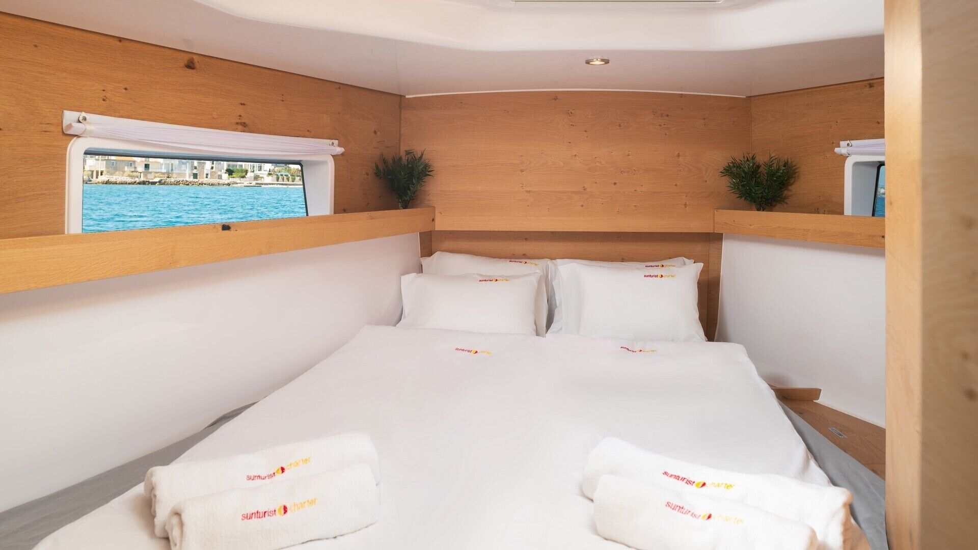 A bedroom with a wooden headboard, a bed with white linens, and a window with a view of a pool.