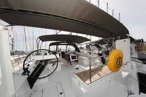A sailboat's deck with a steering wheel, control panel, and a yellow life buoy. - Sun-Kissed Sailing Adventure in Zadar, Croatia (Bibinje)
