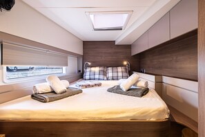A modern bedroom with a large bed, two bedside tables, a skylight, and a window with a view of a body of water. - Sun-Kissed Sailing Adventure in the Ionian Islands, Lefkada (Lefkada)