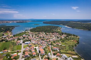 Vue aérienne d’une ville côtière, avec des quartiers résidentiels, un port de plaisance et une vaste étendue d’eau.