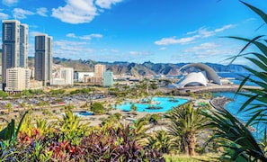 A cityscape with modern buildings, a large pool area, and a distinctive white dome structure.