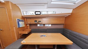 A compact interior with a wooden table, cushioned seating, a map on the wall, and a skylight above. - Sun-kissed Sailing Adventure in Split-Dalmatia, Croatia (Trogir)