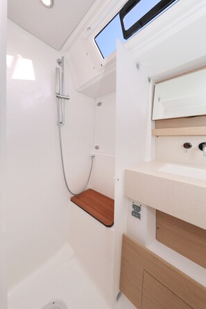 A compact bathroom with a shower, a sink, and a mirror. - Sun-Kissed Sailing Adventure in Zadar, Croatia (Bibinje)