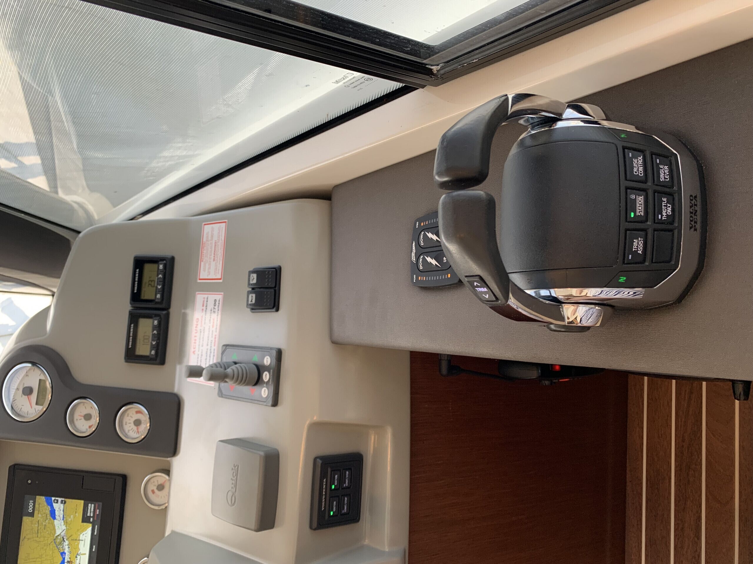 Un panel de control con un volante, velocímetro, tacómetro y pantalla de navegación.
