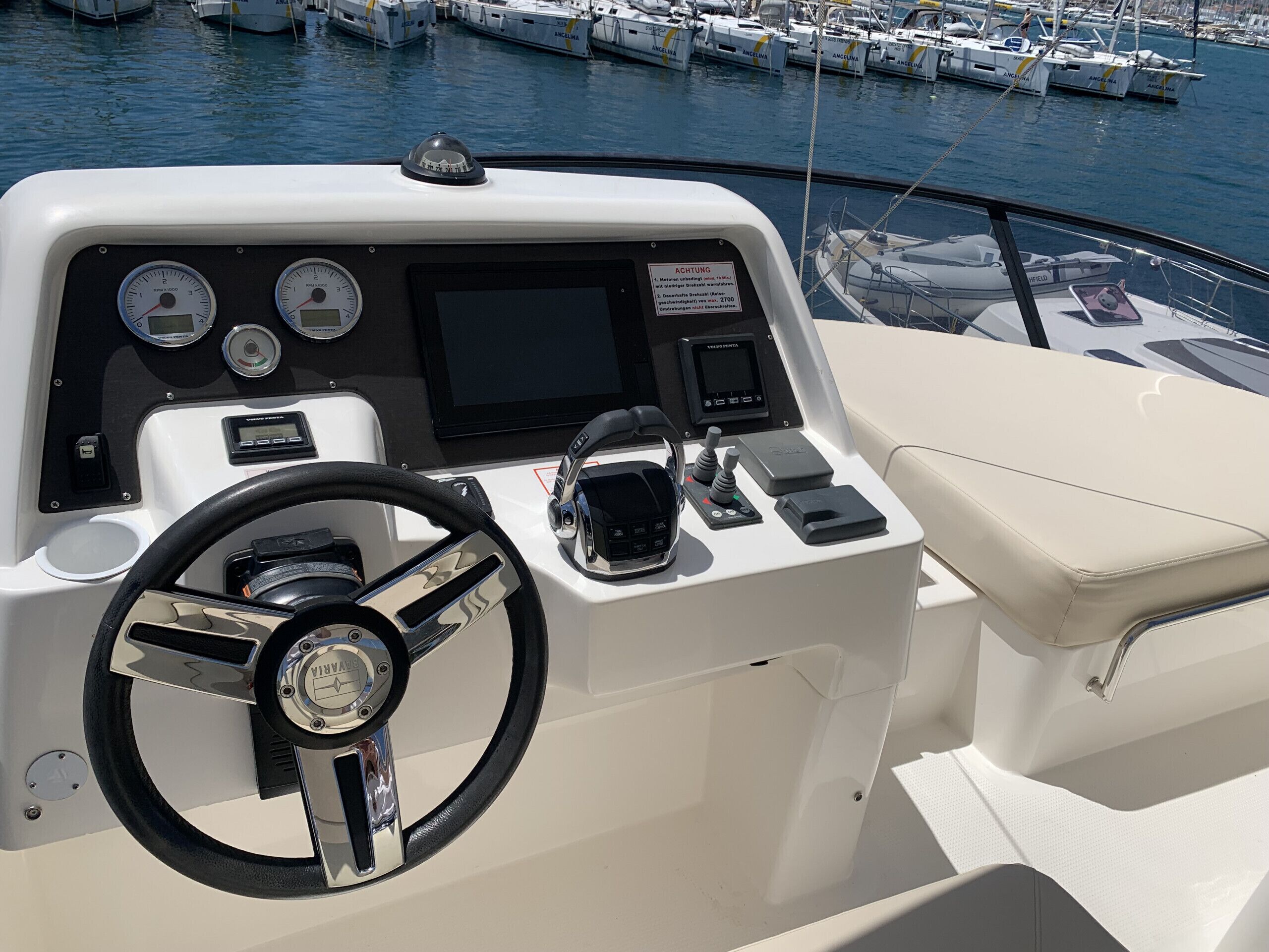 Un poste de pilotage de bateau équipé d’un volant, de plusieurs indicateurs et d’un écran numérique.