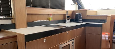 A compact kitchen with a sink, stove, and microwave.