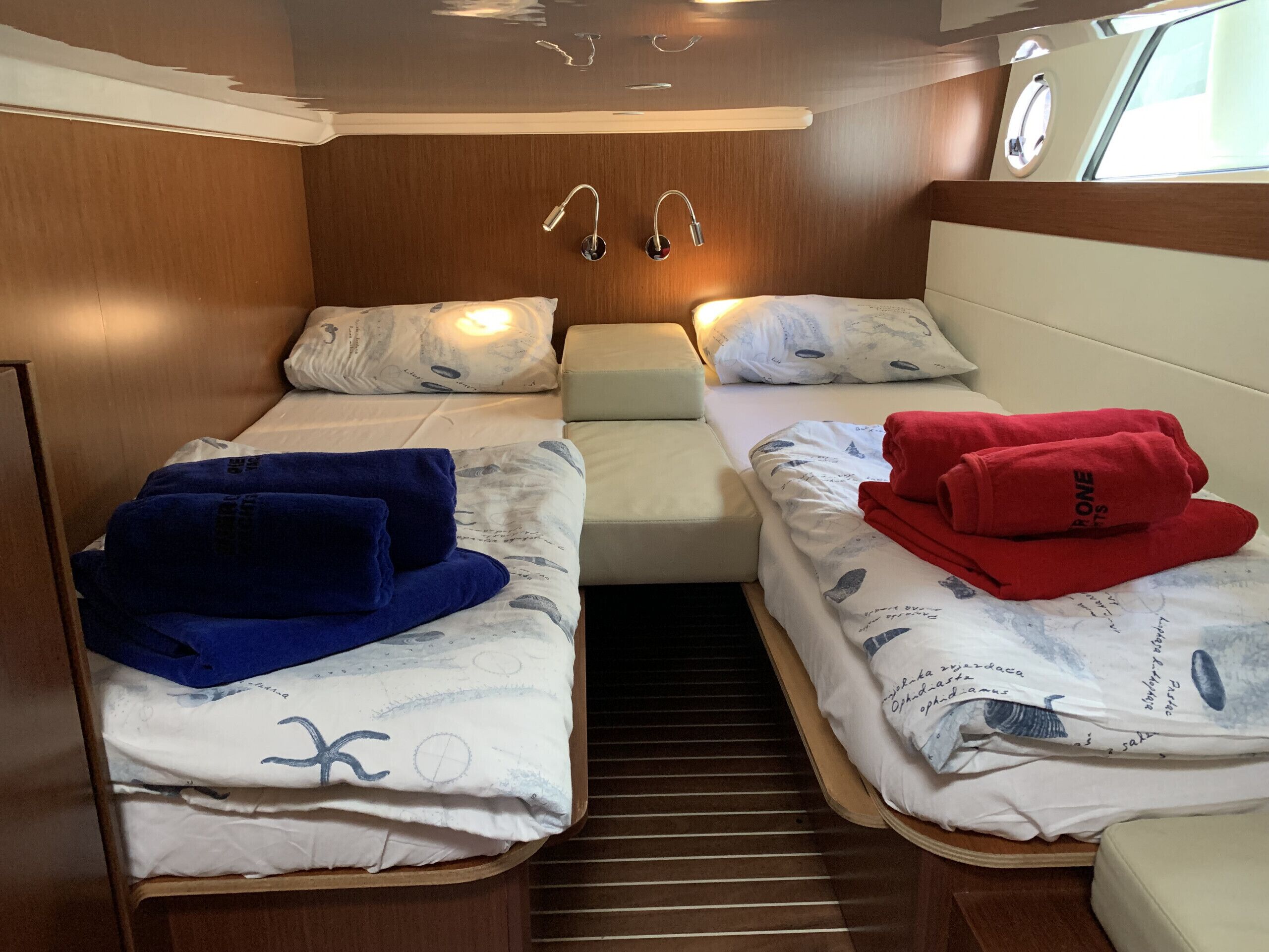 Une cabine compacte équipée de deux lits, chacun comprenant un oreiller et une couverture.