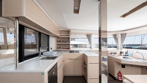 A compact galley with a sink, stove, and storage cabinets. - Sun-kissed Sailing Adventure in Istria, Croatia (Pomer)
