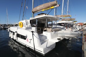 A white boat with 'AIR SPACE' and 'BALI' on the side, docked at a marina. - Sibenik Sun and Beach Sailing Extravaganza: A Croatian Coastal Adventure (Vodice)