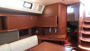 Una cucina compatta con un tavolo centrale, armadietti e un pannello di controllo.