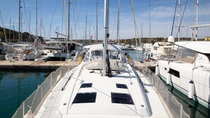 A marina with multiple sailboats docked, featuring a helipad and a covered area. - Sun-kissed Sailing Adventure in Istria, Croatia (Pomer)