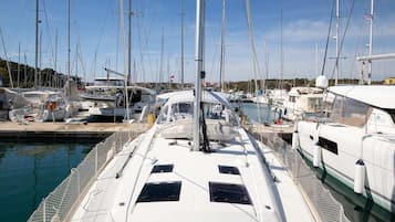 Ein Yachthafen mit mehreren angossenen Segelbooten, inklusive Hubschrauberlandeplatz und überdachtem Bereich.