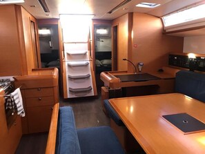 A compact interior with a kitchenette, a dining area, and a sleeping berth.