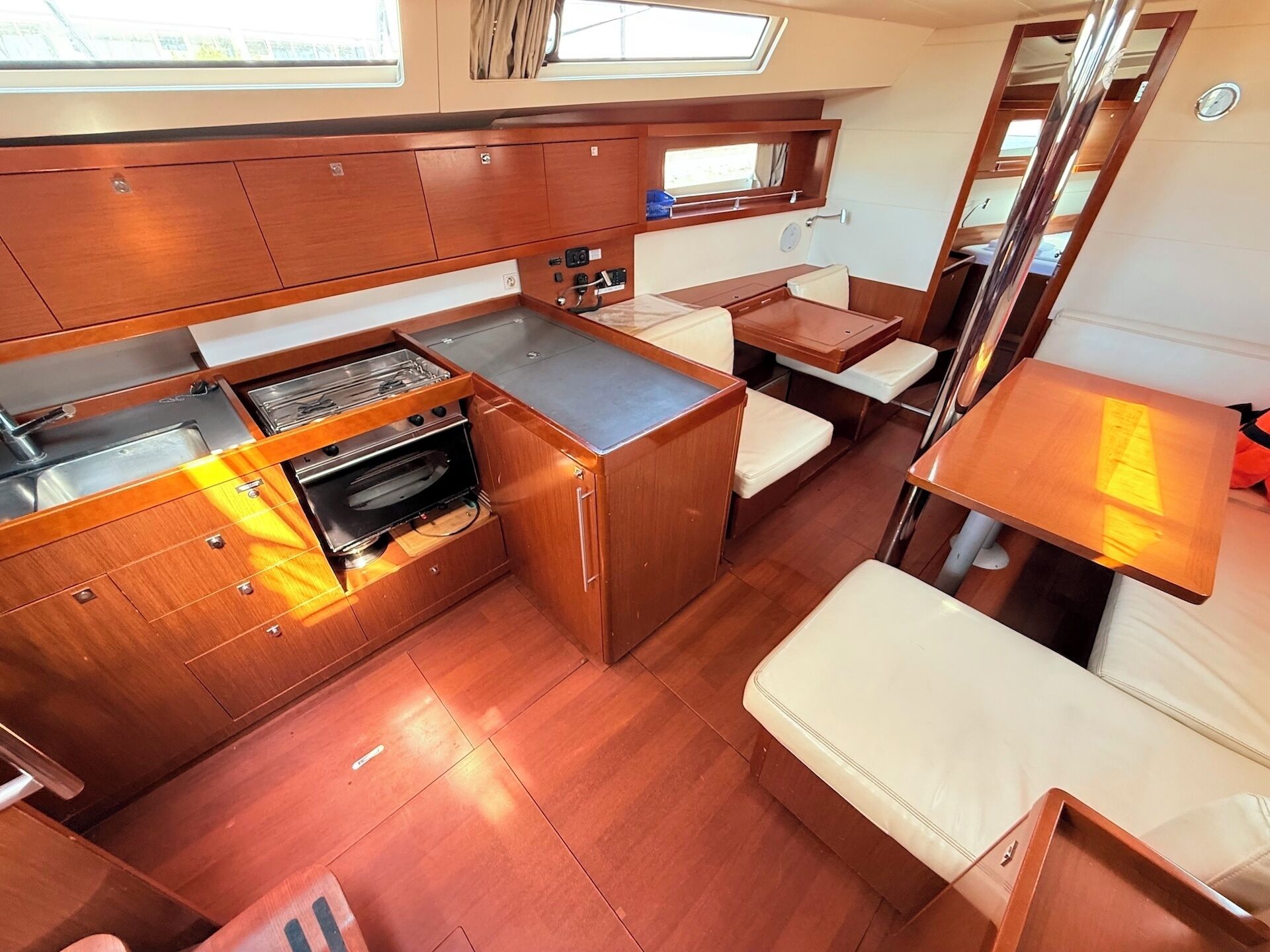 A compact kitchen with a stove, oven, and counter space, a small dining area with a table and chairs, and a window above the counter.