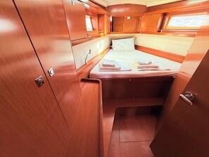 A compact cabin with a bed, a small window, and wooden cabinetry. - Sun-Kissed Sailing Adventure in Zadar, Croatia (Bibinje)