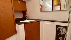 A compact bathroom with a sink, mirror, and shower. - Sun-Kissed Sailing Adventure in Zadar, Croatia (Bibinje)