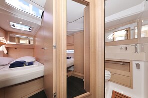 A compact, well-lit interior with a bed, a small bathroom, and a skylight. - Sibenik Sun and Beach Sailing Extravaganza: A Croatian Coastal Adventure (Vodice)