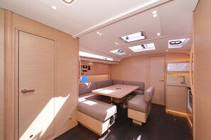 Ein kompaktes Wohnmobil-Interieur mit Essbereich, einer Küchenzeile und einem kleinen Badezimmer.