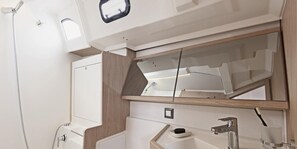 Une salle de bain avec une douche, un lavabo et un miroir.