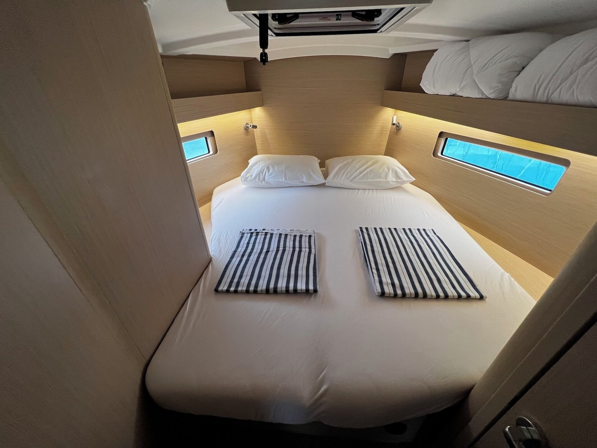 Una cama individual con dos almohadas y almohadas a rayas en la cama inferior.