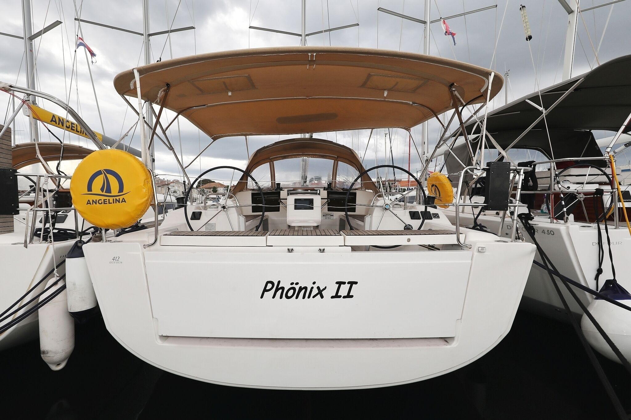 A boat named 'Phönix II' with a cabin and a covered deck area.