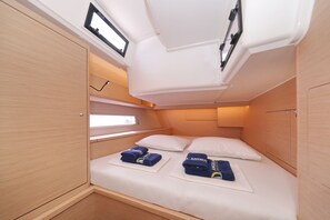 A compact, well-lit room with a bed, two pillows, and neatly folded towels. - Sun-Kissed Sailing Adventure in Northern Croatia (Punat)