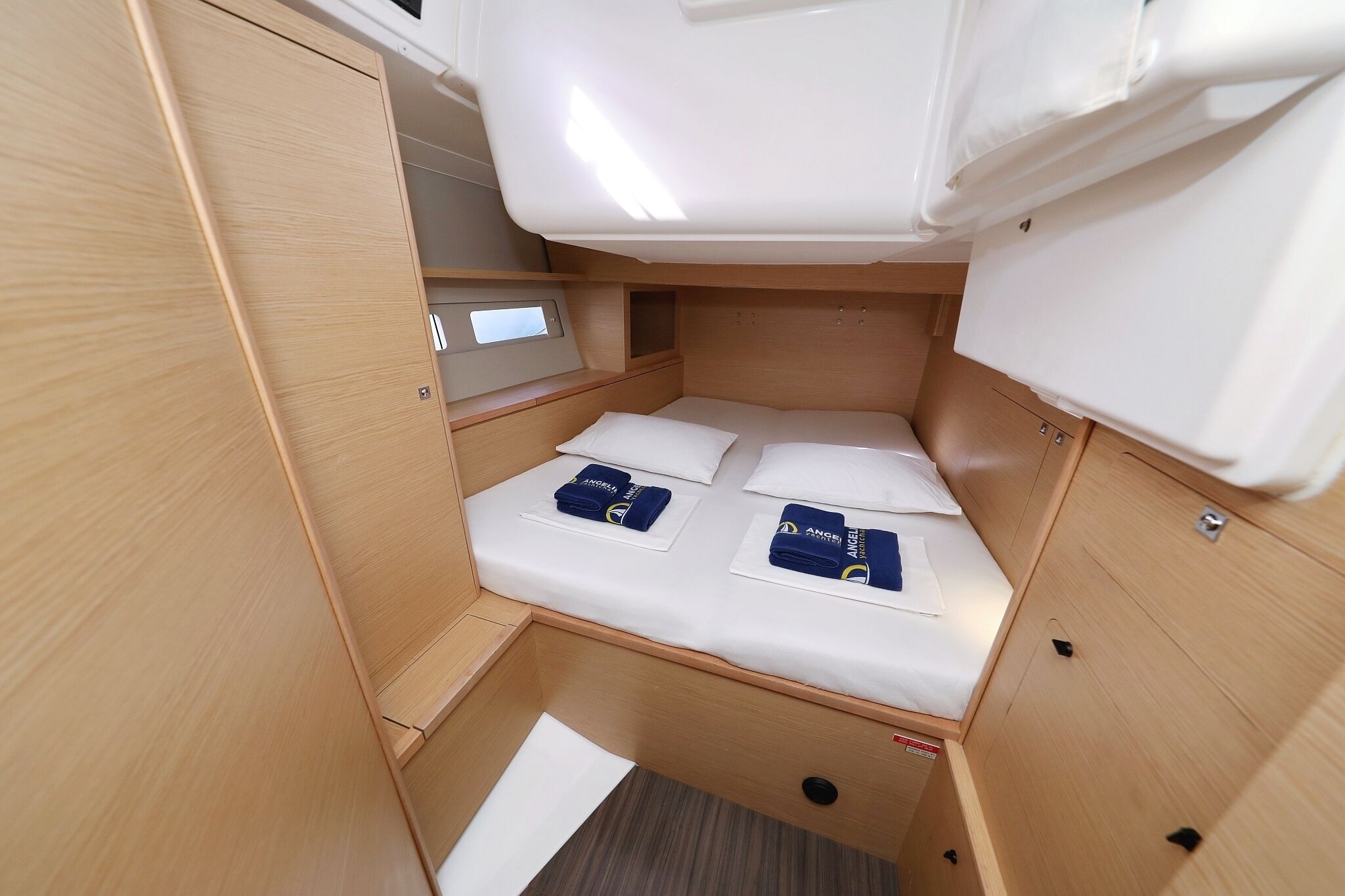 A compact, well-organized sleeping area with a bed, storage compartments, and a small control panel.