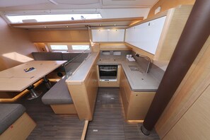 A compact kitchenette with a sink, stove, and storage cabinets. - Sun-Kissed Sailing Adventure in Zadar, Croatia (Bibinje)