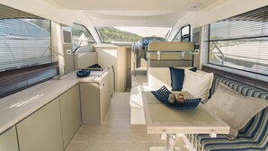 A yacht interior with a dining area, a seating area, and a control panel. - Sun-Kissed Sailing Adventure in Zadar, Croatia (Bibinje)