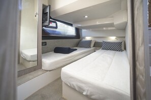 A compact, well-lit cabin with two beds, a small seating area, and a window with blinds. - Sun-Kissed Sailing Adventure in Zadar, Croatia (Bibinje)