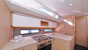 Una cocina compacta con estufa, dos ventanas y una puerta.