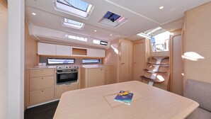 Una cocina compacta con electrodomésticos integrados, un comedor con mesa y un ventanal para luz natural.