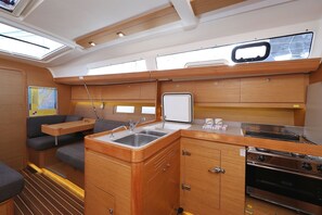 A compact galley with a sink, stove, and seating area. - Sun-kissed Sailing Adventure in Split-Dalmatia, Croatia (Trogir)