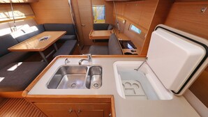A compact kitchenette with a sink, a small table, and a seating area. - Sun-kissed Sailing Adventure in Split-Dalmatia, Croatia (Trogir)