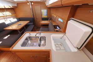 A compact kitchenette with a sink, a small table, and a seating area. - Sun-kissed Sailing Adventure in Split-Dalmatia, Croatia (Trogir)