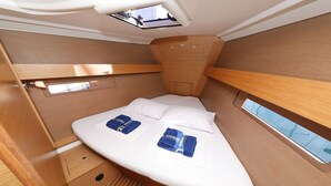 A compact, well-lit cabin with a bed, a skylight, and a small window. - Sun-kissed Sailing Adventure in Split-Dalmatia, Croatia (Trogir)