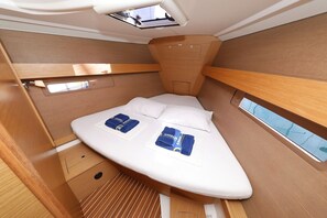 A compact, well-lit cabin with a bed, a skylight, and a small window. - Sun-kissed Sailing Adventure in Split-Dalmatia, Croatia (Trogir)