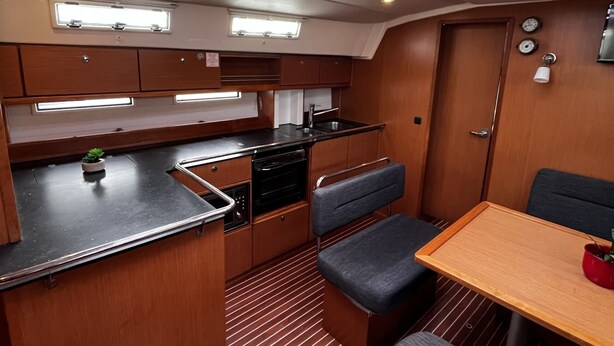A compact kitchen with a central island, overhead skylights, and a dining area with a bench. - Sun-Kissed Sailing Adventure in Zadar, Croatia (Bibinje)