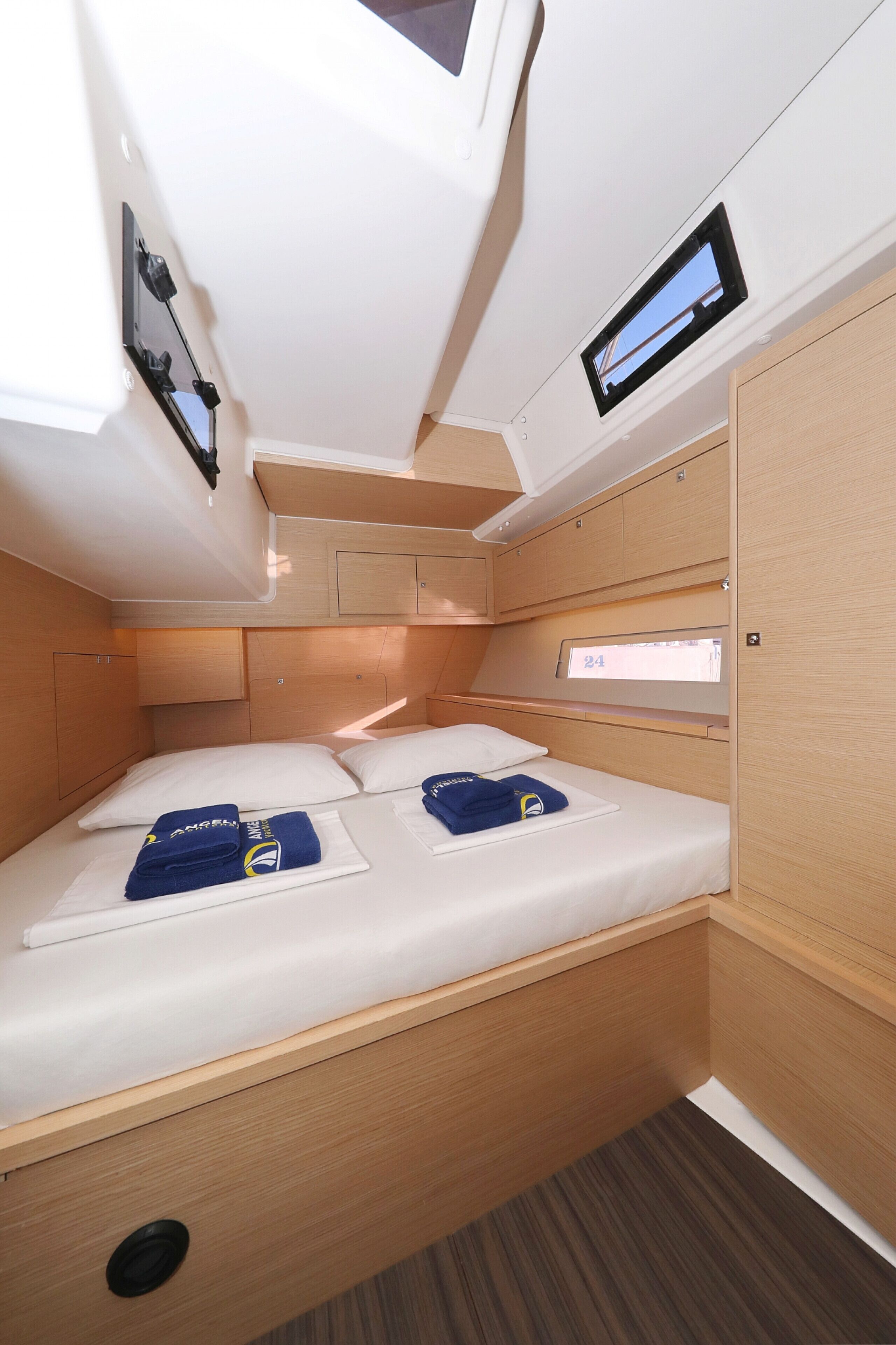 A compact, well-lit cabin with a single bed, built-in storage, and a small window.