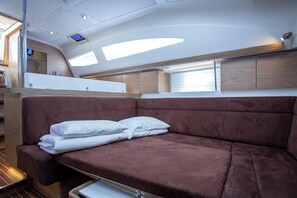 Ein kompakter, moderner Innenraum mit einem braunen Sofa, einer kleinen Küchenzeile und einem Fenster, das für natürliches Licht sorgt.