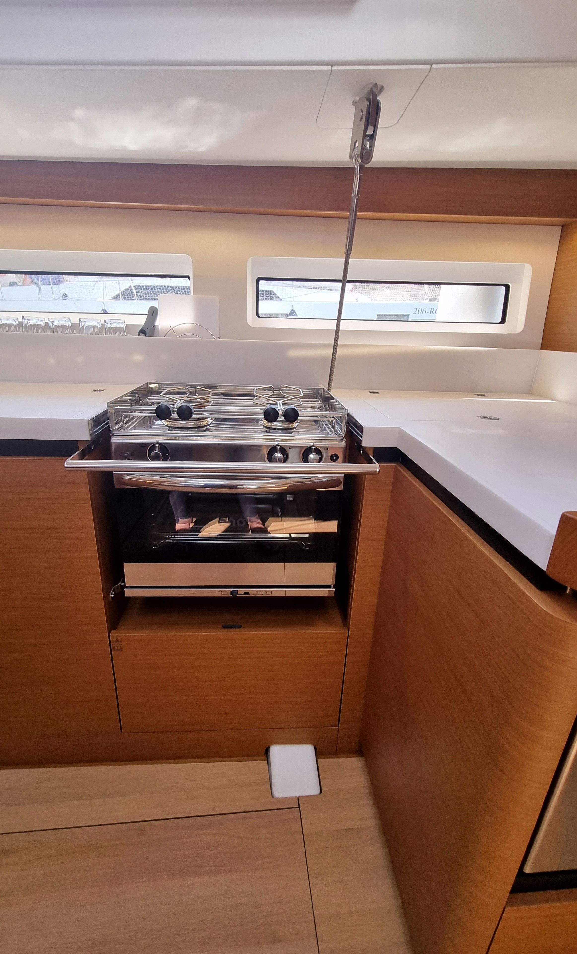Una cucina compatta con piano cottura a gas, mobili in legno e una finestra che offre vista all'esterno.