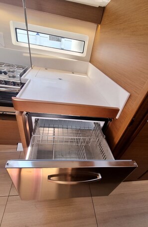 A kitchen with a stainless steel oven, a wooden countertop, and a window above the sink. - Sun-Kissed Sailing Adventure in Split, Croatia (Rogac)